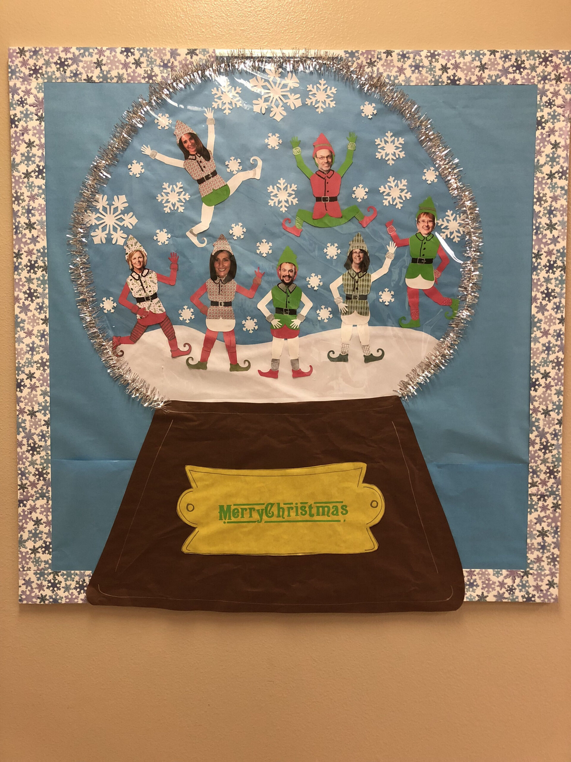 Snow globe bulletin board for Christmas with admin staff as elves